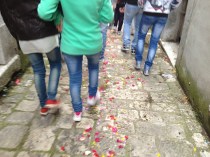 Petals tossed by white robed cherubs.